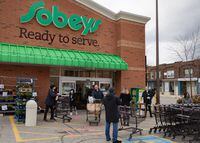 A Sobeys on Danforth Avenue in Toronto has staff cleaning carts and customers hands as they enter the store. People wait to safely shop with physical distancing in place as the COVID-19 pandemic continues. April 15, 2020(Melissa Tait / The Globe and Mail)