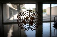 FILE PHOTO: The United Nations logo is seen on a window in an empty hallway at United Nations headquarters in New York, U.S., September 21, 2020. REUTERS/Mike Segar/File Photo