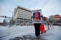 A protestor stands outside of the Warren E. Burger Federal Building and U.S. Courthouse before opening arguments of the civil trial of three former Minneapolis police officers, Tou Thao, J. Alexander Kueng and Thomas Lane, charged with violating George Floyd's civil rights when they took part in his deadly arrest in St. Paul, Minnesota, U.S., January 24, 2022.  REUTERS/Eric Miller