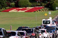 FILE PHOTO: People cross the U.S.-Canadian border near a flag made of flowers after Canada opened the border to vaccinated Americans in Blaine, Washington, U.S., August 9, 2021.  REUTERS/David Ryder/File Photo