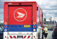 A Canada Post employee climbs into a mail truck in Halifax on July 6, 2016.