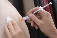 A person receives their COVID-19 vaccine during a drive-thru clinic at Richardson stadium in Kingston, Ont., Friday, Jul. 2, 2021.&nbsp;Some Ontario health units are taking a harder line than the province on COVID-19 vaccination rules for youth sports. THE CANADIAN PRESS/Lars Hagberg