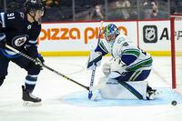 Jan 27, 2022; Winnipeg, Manitoba, CAN;  Winnipeg Jets forward Cole Perfetti (91) looks for the rebound off Vancouver Canucks goalie Spencer Martin (30) during the second period at Canada Life Centre. Mandatory Credit: Terrence Lee-USA TODAY Sports