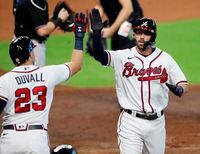 Atlanta Braves' Dansby Swanson gets a high-five from Adam Duvall after hitting a home run during the second inning in Game 2 of the National League Division Series against the Miami Marlins on Oct. 7, 2020. The Braves beat the Marlins 2-0.