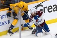 Nashville Predators defenseman Matt Benning (5) and Colorado Avalanche left wing J.T. Compher (37) fight for the puck during the third period in Game 3 of an NHL hockey Stanley Cup first-round playoff series Saturday, May 7, 2022, in Nashville, Tenn. The Avalanche won 7-3. (AP Photo/Mark Zaleski)