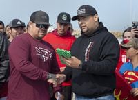 Sipekne'katik First Nation Chief Michael Sack, right, presents the first lobster licence and trap tags to Randy Sack, son of the late Donald Marshall Jr., on the wharf in Saulnierville, N.S., on Sept. 17, 2020.