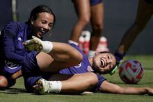 U.S. national team players Sophia Smith, right, Mallory Pugh laugh after colliding with each other during practice for a match against Nigeria Tuesday, Aug. 30, 2022, in Riverside, Mo. Women’s soccer in the United States has struggled with diversity, starting with a pay-to-play model that can exclude talented kids from communities of color.(AP Photo/Charlie Riedel)