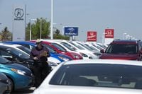 A man takes inventory of new vehicles at a Nissan dealership in Hamilton, Ontario on Thursday,  May 14, 2015. 