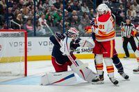 Oct 20, 2023; Columbus, Ohio, USA;  Calgary Flames center Nazem Kadri (91) deflects the puck under the mask of Columbus Blue Jackets goaltender Spencer Martin (30) in the second period at Nationwide Arena. Mandatory Credit: Aaron Doster-USA TODAY Sports