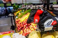 A couple walk in the produce aisle as a netted bag is seen up for sale the IGA supermarket in Saint-Leonard in Montreal on Dec. 10, 2019.