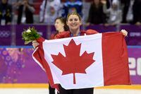 FILE - In this Feb. 21, 2014, file photo, Canada's Hayley Wickenheiser celebrates with the Canadian flag after beating the USA 3-2 in overtime at the Sochi Winter Olympics in Sochi, Russia. With a laugh, Kim Pegula's competitive nature kicked in when the subject of the Toronto Maple Leafs hiring Hayley Wickenheiser was broached. Impressed as the Sabres president was by the gender-breaking move in August, Pegula's first reaction was wondering how Buffalo's cross-border rival beat her to the punch in making Wickenheiser the NHL's first female to hold a hockey operations role as assistant director of player development. "Darn it," Pegula said, smiling. "I wish I would've done it first." (AP Photo/Paul Chiasson, The Canadian Press, File)