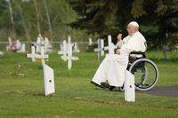 Pope Francis prays at a gravesite at the Ermineskin Cree Nation Cemetery in Maskwacis, Alta., during his papal visit across Canada on Monday, July 25, 2022. THE CANADIAN PRESS/Nathan Denette