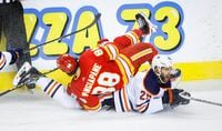 Edmonton Oilers defenceman Darnell Nurse, right, grimaces as Calgary Flames forward Andrew Mangiapane falls on him during second period NHL second round playoff hockey action in Calgary, Alta., Friday, May 20, 2022. THE CANADIAN PRESS/Jeff McIntosh