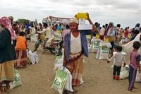 People displaced by conflict receive food aid in the village of Hays, Yemen, on Feb. 22, 2021.