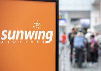 Travellers wait in line at a Sunwing Airlines check-in desk at Trudeau Airport in Montreal on April 20, 2022. Saskatchewan Premier Scott Moe says a decision by Sunwing Vacations to suspend its flights from the Saskatoon and Regina airports for a month is irresponsible. THE CANADIAN PRESS/Graham Hughes