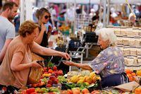 FILE PHOTO: A woman shops at Campo de' Fiori market in Rome, Italy, June 15, 2022. REUTERS/Guglielmo Mangiapane/File Photo
