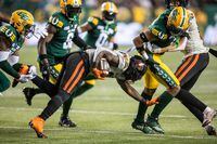 B.C. Lions' Taquan Mizzell (25) gets tackled by Edmonton Elks Tony Jones (left) during first half CFL action in Edmonton, on Friday, September 22, 2023.  THE CANADIAN PRESS/Amber Bracken