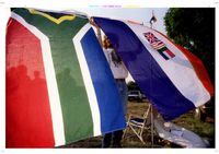 JOH22:SAFRICA-FLAG;PRETORIA;26APR94 - A flag seller displays what could soon be a collector's item -- South Africa's old apartheid-tainted flag (R) April 26. The old flag will be lowered for the last time at one minute to midnight and the new one (L) will be raised in its place. af/Christine Grunnet REUTER