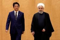 Iranian President Hassan Rouhani, right, and Japanese Prime Minister Shinzo Abe, left, attend a guard of honor guard ceremony at the prime minister's office in Tokyo, Friday, Dec. 20, 2019. Rouhani is in Tokyo to meet with Prime Minister Abe on Friday in hopes of easing a nuclear impasse between Tehran and Washington and reduce tensions in the Middle East. (Du Xiaoyi/Pool Photo via AP)