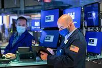 Trader Fred DeMarco, right, works on the floor of the New York Stock Exchange on April 22.
