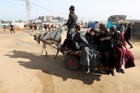 Displaced Palestinians, who fled their houses due to Israeli strikes, sit on a horse-drawn carriage in Rafah in the southern Gaza Strip, January 8, 2024. REUTERS/Ibraheem Abu Mustafa