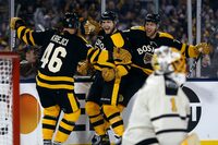 Boston Bruins' Jake DeBrusk (74) celebrates his go-ahead goal against Pittsburgh Penguins' Casey DeSmith (1) with teammates David Krejci (46) and Taylor Hall (71) during the third period of the NHL Winter Classic hockey game, Monday, Jan. 2, 2023, at Fenway Park in Boston. (AP Photo/Michael Dwyer)