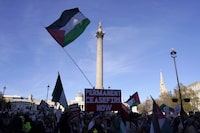Protester hold flags and placards as they take part in a pro-Palestinian demonstration as pass by Trafalgar Square in London, Saturday, Nov. 25, 2023. (AP Photo/Alberto Pezzali)