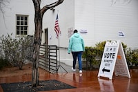 A person walks in the rain past signage displayed outside of a vote center on Election Day during the Nevada 2024 presidential primary election in Las Vegas, Nevada, on February 6, 2024. (Photo by Patrick T. Fallon / AFP) (Photo by PATRICK T. FALLON/AFP via Getty Images)