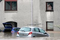 A woman talks on the phone as she looks out of a window onto the flooded property below, in Brechin, Scotland, Friday Oct. 20, 2023. The gale-force winds are expected to hit hardest the eastern part of Denmark's Jutland peninsula and the Danish islands in the Baltic Sea. But the British Isles, southern Sweden, northern Germany and parts of Norway also on the path of the storm, named Babet by U.K.’s weather forecaster, the Met Office. (Andrew Milligan/PA Wire/PA via AP)