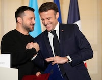 EDITORS NOTE: Graphic content / France's President Emmanuel Macron (R) and  Ukraine's President Volodymyr Zelensky (L) react at the presidential Elysee palace in Paris on February 16, 2024, after signing a bilateral security agreement. French President Emmanuel Macron and Ukraine's Volodymyr Zelensky on February 16, 2024 signed a security pact calling for French military and civilian aid for Kyiv in its war against Russia, officials said. (Photo by Thibault Camus / POOL / AFP) (Photo by THIBAULT CAMUS/POOL/AFP via Getty Images)