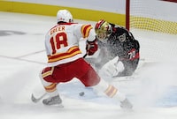 Calgary Flames left wing A.J. Greer sprays Ottawa Senators goaltender Joonas Korpisalo as he makes a save during first period NHL action, Saturday, November 11, 2023 in Ottawa. THE CANADIAN PRESS/Adrian Wyld