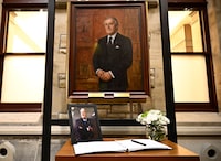 A photograph and book of condolences for Members of Parliament to sign are seen in front of the official portrait of former prime minister Brian Mulroney, in the antechamber to the House of Commons on Parliament Hill as Canadians mourn his death on Thursday at the age of 84, in Ottawa, Friday, March 1, 2024. THE CANADIAN PRESS/Justin Tang