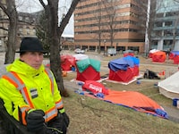 Volunteer Stephen Wilsack spent Sunday covering tents with tarps for unhoused people at an encampment in Grand Parade square downtown Halifax in preparation for the city's first big winter storm. (Lindsay Jones)