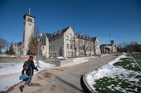 A pedestrian walking along the path near Kingston Hall on the campus of Queen's University in Kingston, Ont., is photographed on Jan 20 2021.