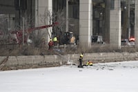 Emergency crews work to retrieve a car that crashed through the ice into the Keating Channel in Toronto on Saturday Jan. 20, 2024. Toronto Fire Services says their crews were unable to rescue a person from Lake Ontario after a vehicle crashed through the ice along the downtown waterfront. THE CANADIAN PRESS/Arlyn McAdorey