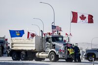 The lawyer for one of three men on trial for their roles in the border blockade at Coutts, Alta, argued Thursday his client was nothing more than a messenger. Drivers work to move a gravel truck at a protest blockade at the Canada-United States border at Coutts, Alta., Wednesday, Feb. 2, 2022. THE CANADIAN PRESS/Jeff McIntosh