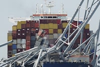 FILE - The container ship Dali is stuck under part of the Francis Scott Key Bridge after the ship hit the bridge Tuesday March 26, 2024, in Baltimore, Md. (AP Photo/Steve Helber, File)