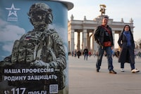 People walk past a desk promoting Russian army service in Moscow, Russia April 12, 2023.  REUTERS/Yulia Morozova