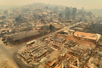 Aerial view of a bus terminal in the El Olivar commune after a forest fire that affected the hills of Viña del Mar, Chile, taken on February 3, 2024. The region of Valparaiso and Viña del Mar, in central Chile, woke up on Saturday with a partial curfew to allow the movement of evacuees and the transfer of emergency equipment in the midst of a series of unprecedented fires, authorities reported. (Photo by Javier TORRES / AFP) (Photo by JAVIER TORRES/AFP via Getty Images)