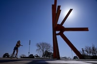 FILE - A woman skateboards near a sculpture as she enjoys unseasonably warm weather, Feb. 27, 2024, in Milwaukee. Earth has exceeded global heat records in February, according to the European Union climate agency Copernicus. (AP Photo/Morry Gash, File)