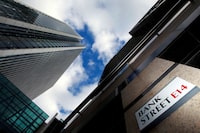 A sign for Bank Street and high rise offices are seen in the financial district in Canary Wharf in London, Britain, October 21, 2010.