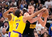 Los Angeles Lakers guard Gabe Vincent (7) pressures Denver Nuggets center Nikola Jokic, right, during the second half in Game 2 of an NBA basketball first-round playoff series Monday, April 22, 2024, in Denver. (AP Photo/Jack Dempsey)