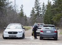 An RCMP officer talks with a local resident before escorting them home at a roadblock in Portapique, N.S. on Wednesday, April 22, 2020. The morning after a gunman killed 13 people in northern Nova Scotia, the RCMP were unaware he had resumed shooting people until frantic 911 calls started coming in shortly after 9:30 a.m. THE CANADIAN PRESS/Andrew Vaughan