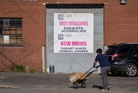 A "Now Hiring," sign is displayed on a business Tuesday, May 30, 2023 in Montreal. Statistics Canada released its latest snapshot of how the job market is doing in the country. THE CANADIAN PRESS/Christinne Muschi