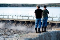 Alberta's irrigation district managers are proposing a $5-billion plan for water storage and conservation in the province's south as the region faces increasingly tight supplies of the vital resource. People watch as water from the Bow River flows through the Bassano Dam before meeting up with the South Saskatchewan River in Bassano, Alta., on Saturday, June 22, 2013. THE CANADIAN PRESS/Nathan Denette