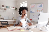 African American Female Employee Sit at Desk in Office Talk on Video Call With Client, Smiling Young Businesswoman Have Webcam Conference at Workplace, Virtual Event Concept