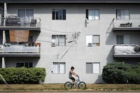 Window mounted air conditioners and exhaust hoses from portable units are seen in apartment windows, in Burnaby, B.C., on Saturday, August 5, 2023. THE CANADIAN PRESS/Darryl Dyck