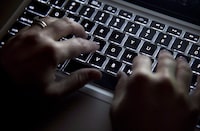 A woman uses a computer keyboard, in North Vancouver, on December, 19, 2012. The Ontario government says its vaccination database was hacked and the personal information of about 360,000 people was involved. THE CANADIAN PRESS/Jonathan Hayward