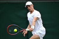 LONDON, ENGLAND - JULY 09: Denis Shapovalov of Canada plays a backhand against Roman Safiullin in the Men's Singles fourth round match during day seven of The Championships Wimbledon 2023 at All England Lawn Tennis and Croquet Club on July 09, 2023 in London, England. (Photo by Shaun Botterill/Getty Images)