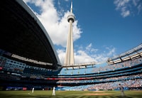 The CN Tower looms over the Toronto Blue Jays and Detroit Tigers as the Rogers Centre's roof is open for the first time in the 2011 MLB baseball season in Toronto Saturday, May 7, 2011. THE CANADIAN PRESS/Darren Calabrese